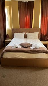 普罗夫迪夫HOTEL THE WHITE HOUSE Plovdiv的一间卧室配有一张床,上面有两条毛巾
