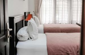 棉兰Pasola Guest House的一间卧室配有三张床和枕头。