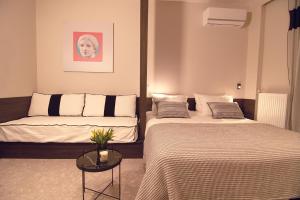 雅典Cityzoe Athens Suites的酒店客房设有两张床和一张桌子。