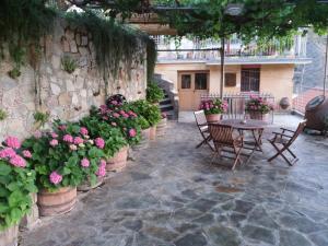 利马索尔Rodous Village House的一个带鲜花和桌椅的庭院