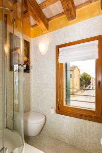 布拉诺岛TIFFANY GOLD的一间带卫生间和玻璃淋浴间的浴室