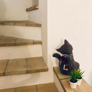兰恰诺IL MELOGRANO La Casa nel Vicoletto的坐在楼梯旁架子上的猫雕像
