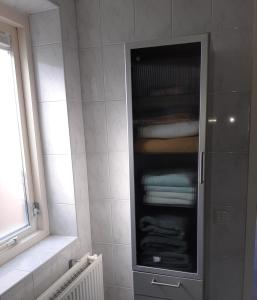 斯塔普霍斯特Bed and Breakfast het Groentje的一间带玻璃柜和毛巾的浴室