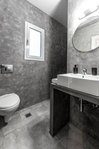 斯巴达Boutique Studios & Apartments - by Avelink的一间带水槽、卫生间和镜子的浴室