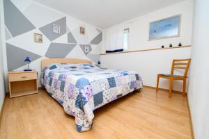 马丁斯契卡Apartmani Noris (app3)的卧室配有1张床、1张桌子和1把椅子