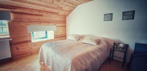 布鲁日Huize Andries的卧室配有一张床铺,位于带木墙的房间内