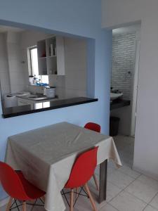 萨尔瓦多Apartamento en Salvador bahía com ar condicionado的厨房配有桌子和2把红色椅子