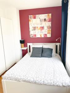 鲁昂Appartement A Deux Pas situé en Hyper Centre Ville的卧室配有白色的床铺和红色的墙壁