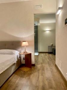 利莫内-苏尔加达Residence Dalco Suites & Apartments的一间卧室配有一张床和一张带台灯的桌子