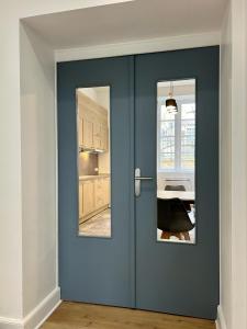 圣西普里安Chai Merlot的厨房里设有两扇窗户的蓝色门