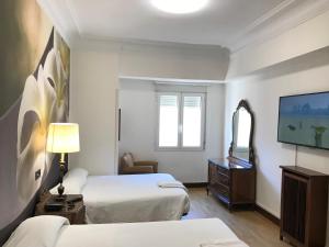 桑坦德拉墨西哥纳旅馆的酒店客房设有两张床和一台平面电视。