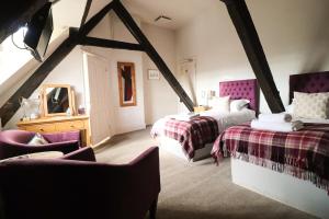 毕晓普斯堡城堡酒店 的阁楼卧室配有两张床和椅子
