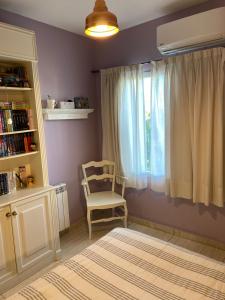 西波列蒂Departamento Nuevo en Cipolletti的一间卧室配有椅子和窗户