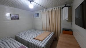 坎普莫朗Pousada Recriare的小房间设有两张床和电视