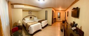 利马奥罗酒店 的酒店客房设有两张床和一台平面电视。