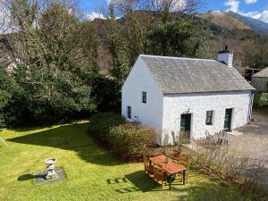 巴拉胡利什The Bothy of Ballachulish House的院子内带桌子的白色小房子