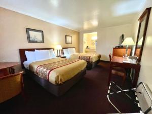 萨默斯波因特Passport Inn Somers Point - Somers Point的酒店客房配有两张床和一张书桌
