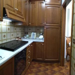蒙特普齐亚诺Casa di nonna Cate的厨房配有木制橱柜和炉灶烤箱。