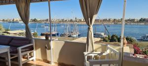 卢克索Senmut Luxory Rooms的享有水景和船景的阳台