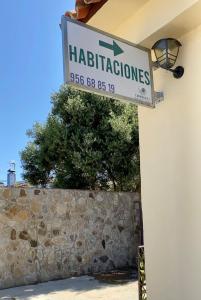 博罗尼亚Habitaciones Carmencita的建筑的一边有石墙的标志
