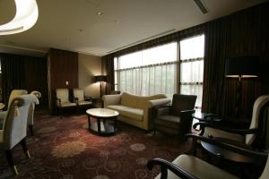 台北福容大飯店台北一館的酒店客房设有沙发、椅子和桌子。