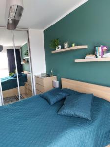 格但斯克Apartament przy stadionie的一间蓝色卧室,配有一张床和镜子