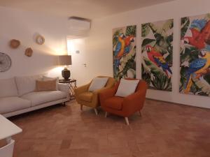 法鲁Casa Algarbe的客厅配有两把椅子和墙上的绘画作品