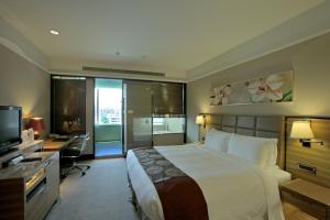 台北福容大飯店台北一館的一间卧室配有一张床、一张书桌和一台电视