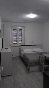 扎达尔EMA HOUSE的卧室配有床、桌子和窗户。