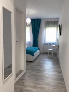 锡比乌Gizell Apartment 1的一间卧室配有床、蓝色窗帘和镜子
