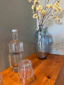 Curvatos蒙吉奥斯乡间别墅温泉酒店的一张带花瓶、一瓶和眼镜的木桌