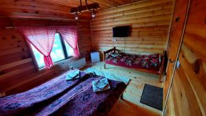 莫伊科瓦茨Log cabin 1 Merdovic的小木屋内一间卧室,配有两张床