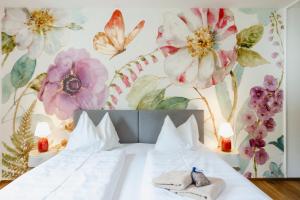 圣沃尔夫冈Das Franzl - Bett & Brot的卧室配有一张墙上鲜花的床