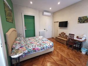 科莱尼奥B&B Ad Quintum Torino的一间卧室配有一张床、一张桌子和一台电视