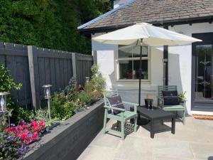 AscogSeaview Cottage的庭院配有桌子、遮阳伞和椅子