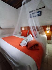 皮帕Villas de Tibau的一间卧室配有带橙色和白色枕头的床