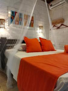 皮帕Villas de Tibau的一间卧室配有两张带橙色枕头的床