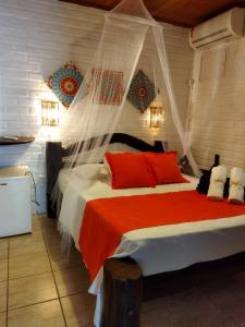 皮帕Villas de Tibau的一间卧室配有一张带红色枕头的大床