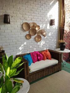 皮帕Villas de Tibau的砖墙上带五颜六色枕头的藤椅