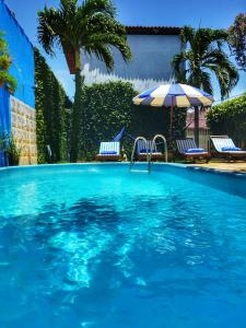 皮帕Villas de Tibau的一个带两把椅子和遮阳伞的游泳池