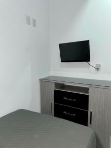 塔里哈Green Space的一间卧室配有一张床和一台平面电视