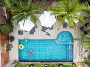 卡伦海滩Baan Sailom Hotel Phuket - Sha Extra Plus的享有带两棵棕榈树的游泳池的顶部景致