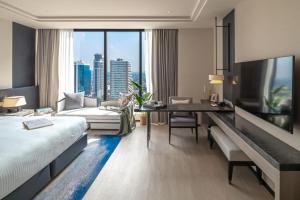 曼谷Ascott Thonglor Bangkok - SHA Plus Certified的酒店客房设有一张床和一张书桌,享有美景。