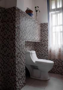 RongliAshraya Boutique Homestay的一间带卫生间和瓷砖墙的浴室