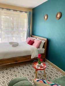 RuakaElegant and cozy studio apartment in Nairobi Ruaka的一间卧室设有一张床和蓝色的墙壁