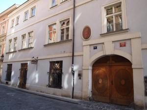 布拉格色温兹多红椅酒店的白色的建筑,在街上有两扇木门