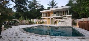 龙目岛库塔Tiu Oasis Lombok的一座房子前面设有游泳池