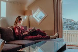 克拉格勒Victoria Hotel Kragerø的坐在沙发上读书的女人