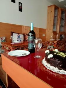 列城Hotel Jigmet, Leh的坐在桌子上的一瓶葡萄酒,还有蛋糕和一杯