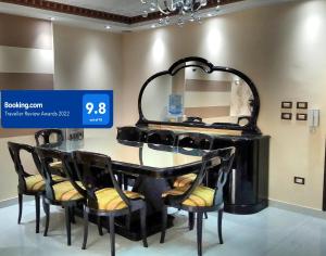 开罗Maadi Apartment - 3 rooms ( Families Only )的一张黑色餐桌,配有椅子和镜子